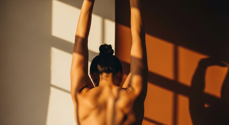 Anonymous person seen from behind reaching overhead in a tall spinal-elongation stretch, warm studio light